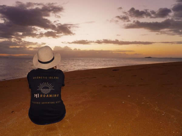 a person with a sunset in the sand on a beach