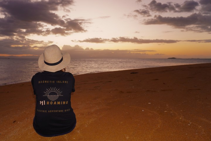 a person with a sunset in the sand on a beach